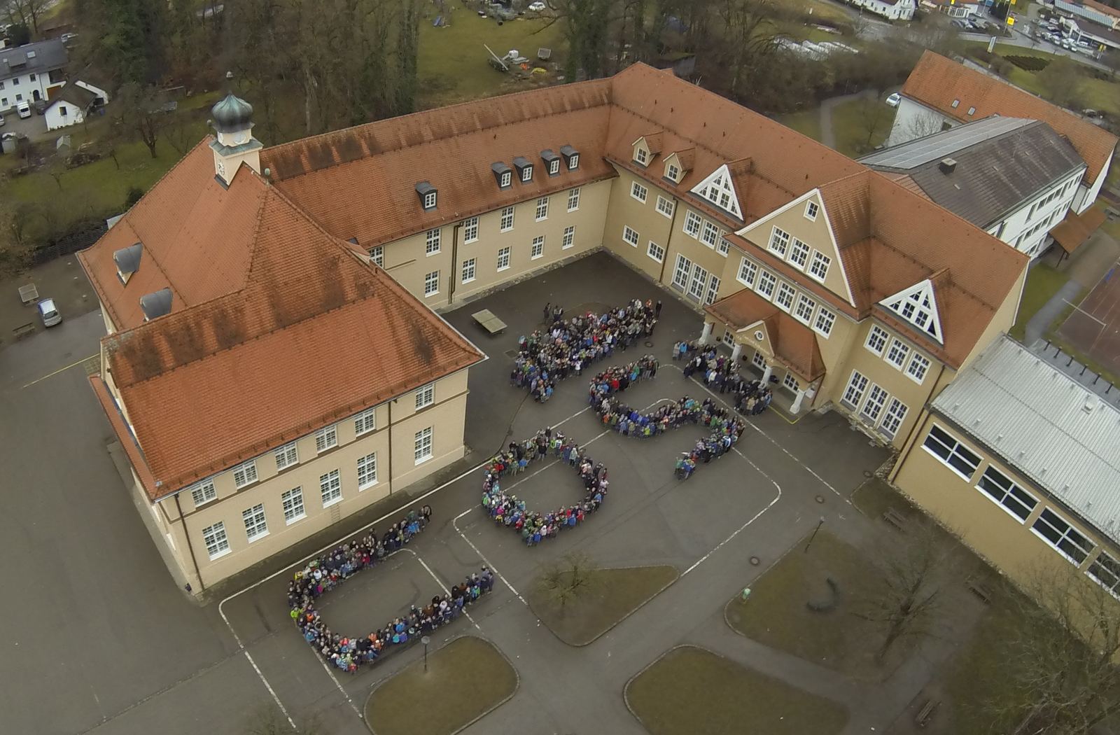 Luftaufnahme der Schule mit Schuelern